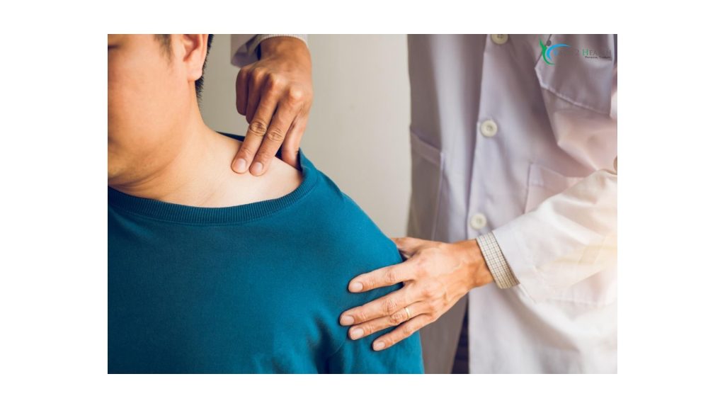 Physical therapist assessing shoulder pain by gently examining a patient’s neck and shoulder area during a physical therapy session.