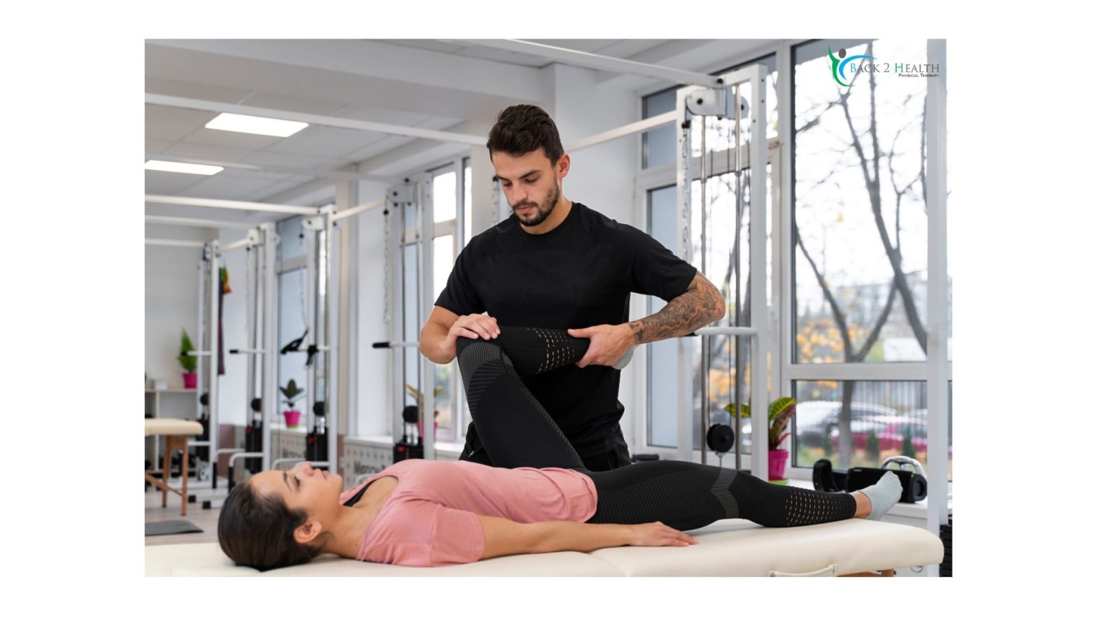 Male physical therapist gently bending and stretching a woman's leg at Back 2 Health clinic for physical therapy services in Brownstown.