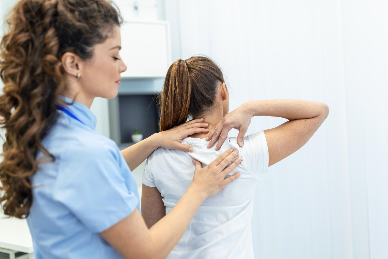 Physical therapist helping a patient with neck pain through therapeutic exercises.