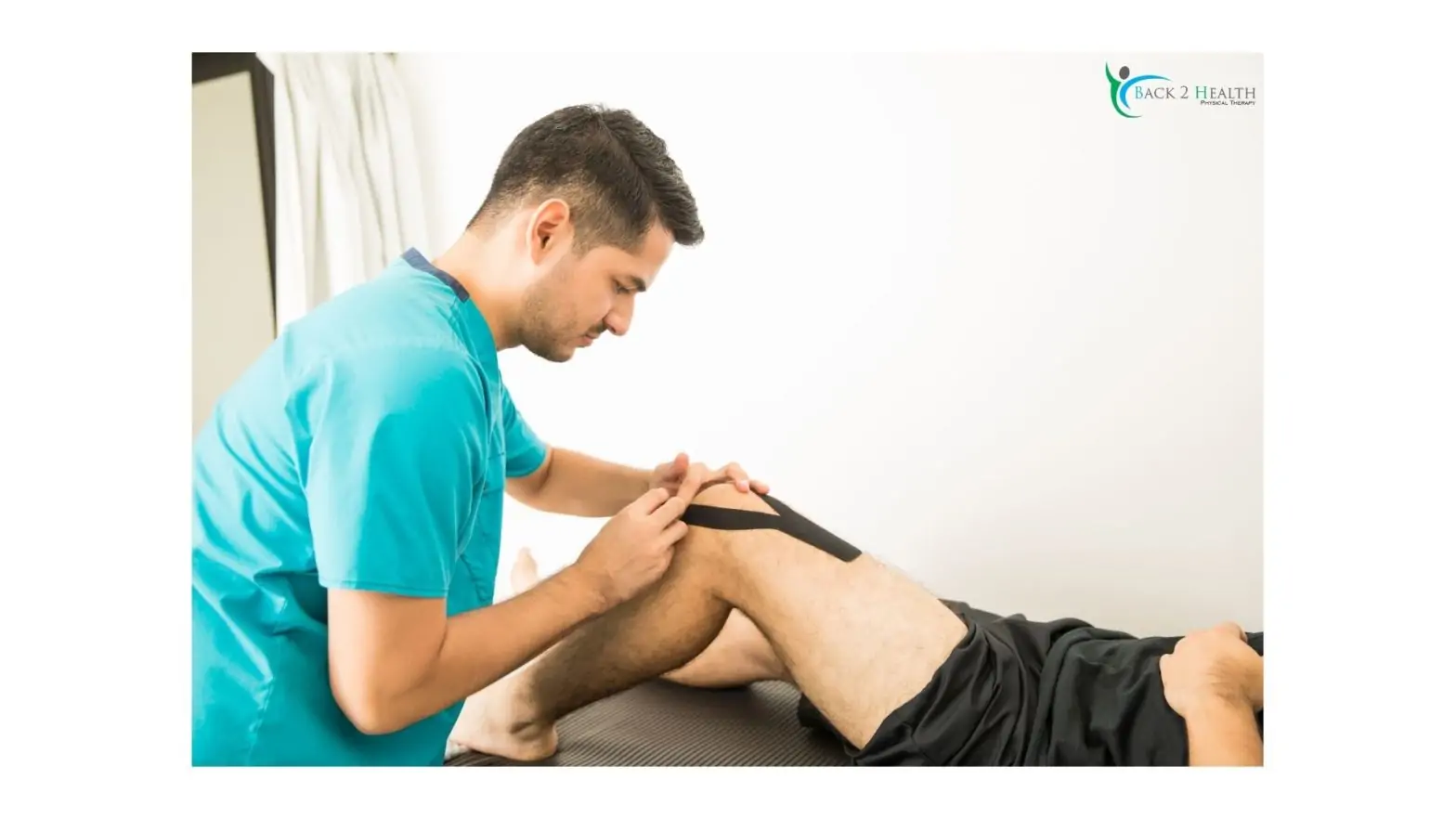 A physical therapist applying black kinesiology tape to a patient's knee at the Back 2 Health clinic.